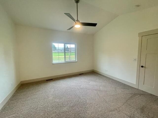 carpeted empty room featuring ceiling fan and vaulted ceiling