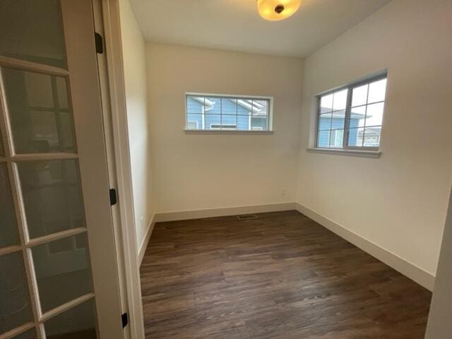 unfurnished room featuring dark wood-type flooring