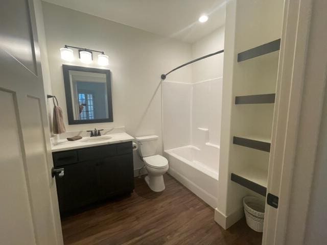 full bathroom featuring vanity, wood-type flooring, shower / bathtub combination, and toilet