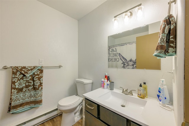 bathroom with wood finished floors, baseboard heating, vanity, and toilet