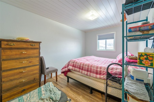 bedroom featuring wooden ceiling, baseboards, and wood finished floors