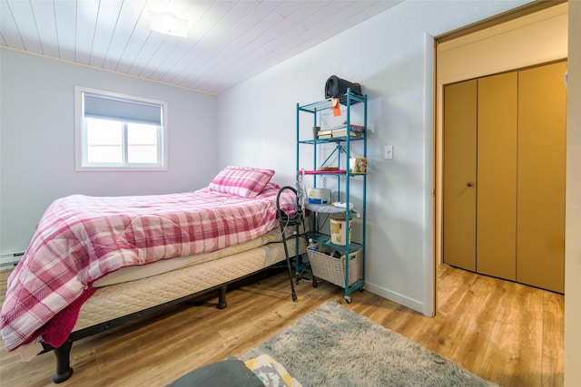 bedroom featuring wooden ceiling, wood finished floors, and baseboards