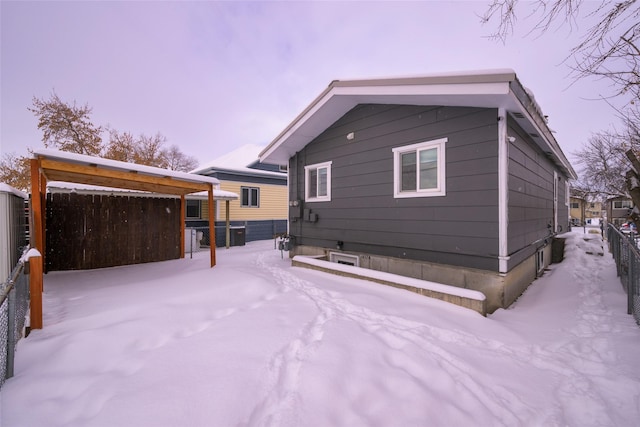 view of snow covered back of property