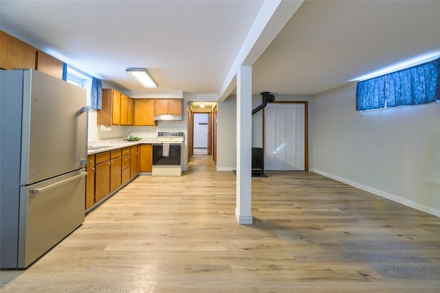 kitchen featuring stainless steel fridge, light hardwood / wood-style floors, and white range with electric stovetop