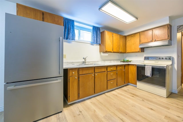 kitchen featuring stainless steel refrigerator, white electric range, light hardwood / wood-style floors, and sink