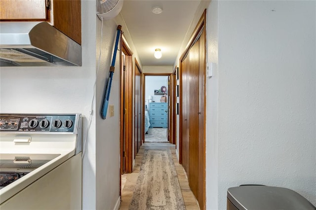 hallway featuring washer / dryer and light hardwood / wood-style floors