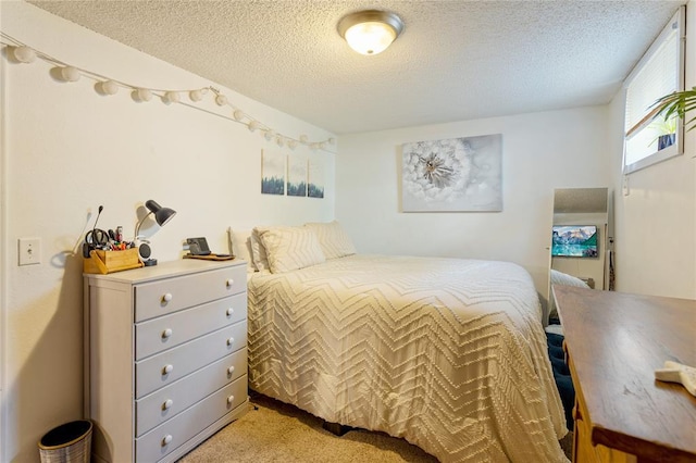 bedroom featuring light carpet and a textured ceiling