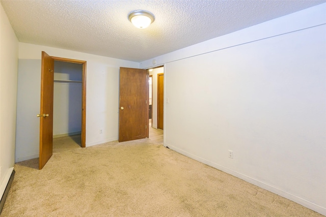 unfurnished bedroom with carpet, a closet, a textured ceiling, and baseboards