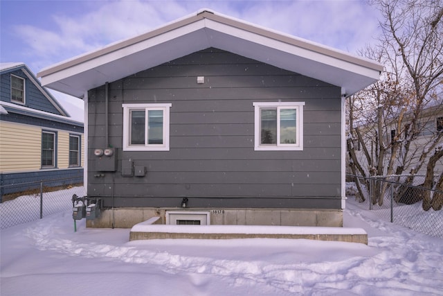 view of snowy exterior with fence