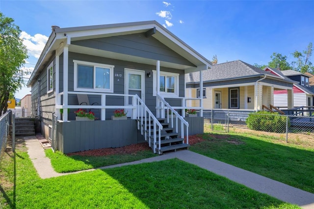 bungalow-style house featuring a front lawn and fence