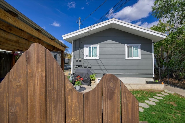 view of side of home featuring fence