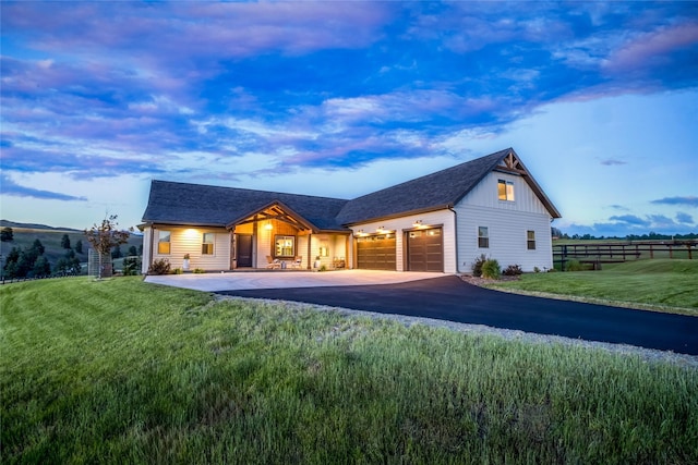 view of front of house featuring an attached garage, fence, driveway, and a front yard