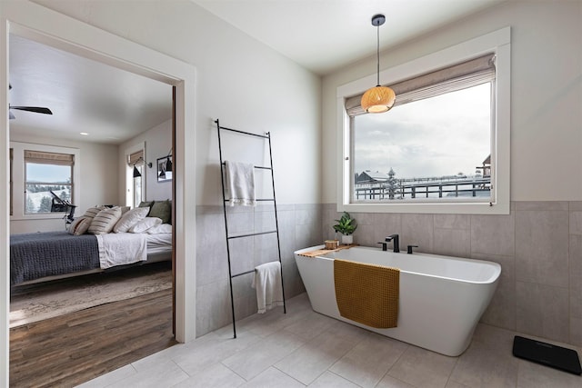 bathroom with tile patterned flooring, tile walls, and a washtub