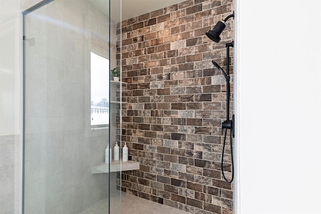 bathroom featuring brick wall and an enclosed shower