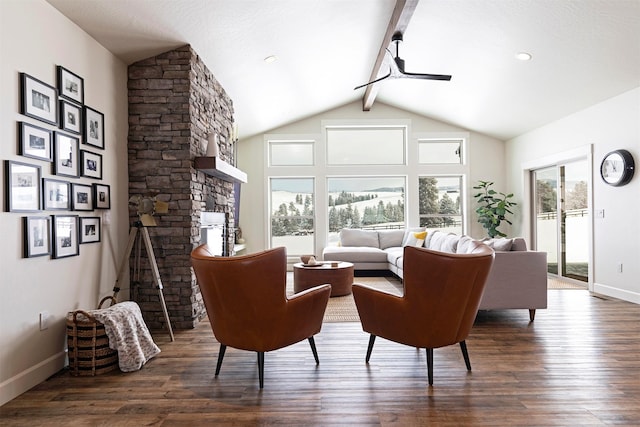 living room featuring dark hardwood / wood-style flooring, a stone fireplace, lofted ceiling with beams, and ceiling fan