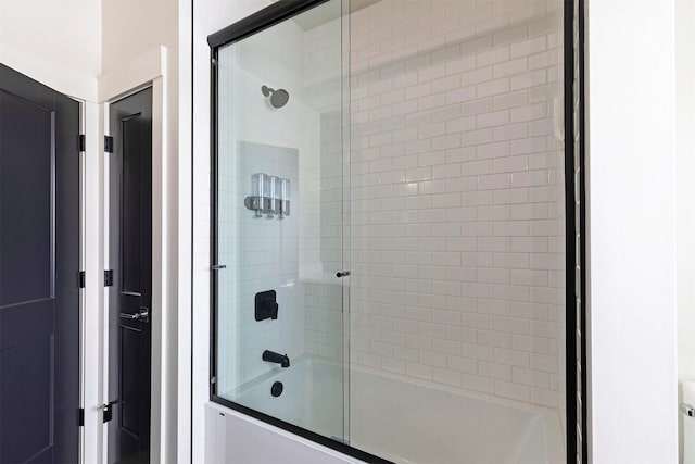 bathroom with bath / shower combo with glass door