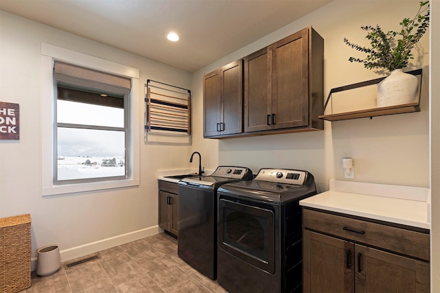 laundry room with cabinets, sink, and washing machine and dryer