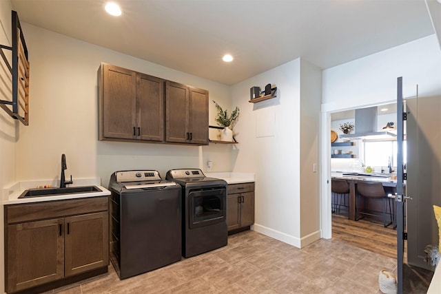 laundry room featuring washer and dryer, sink, and cabinets