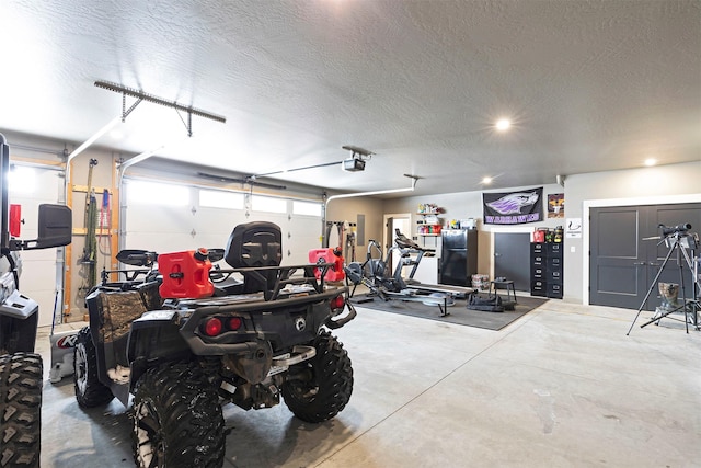 garage with a garage door opener and black fridge