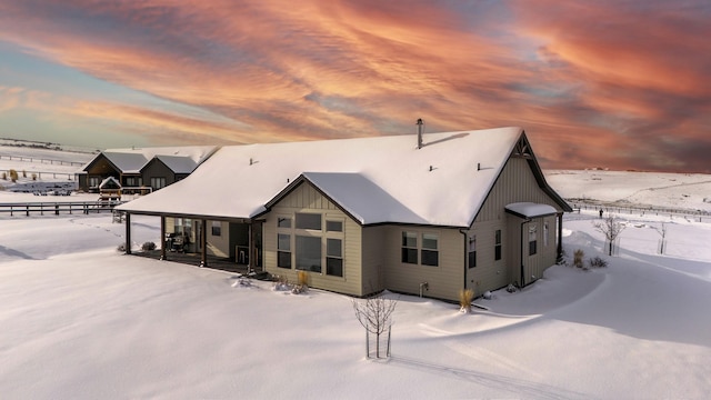 view of snow covered back of property