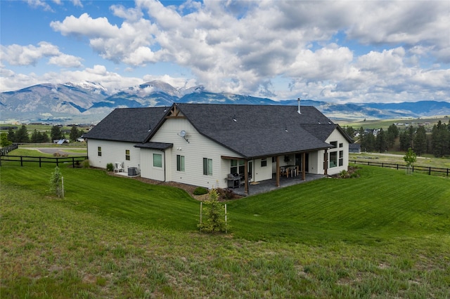 back of property featuring a fenced backyard, a yard, a patio, and a mountain view