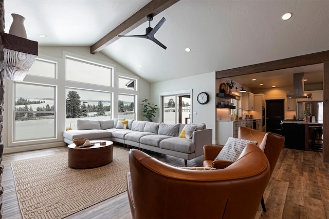 living room with sink, ceiling fan, hardwood / wood-style floors, high vaulted ceiling, and beamed ceiling