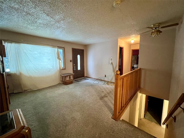 carpeted foyer with a textured ceiling