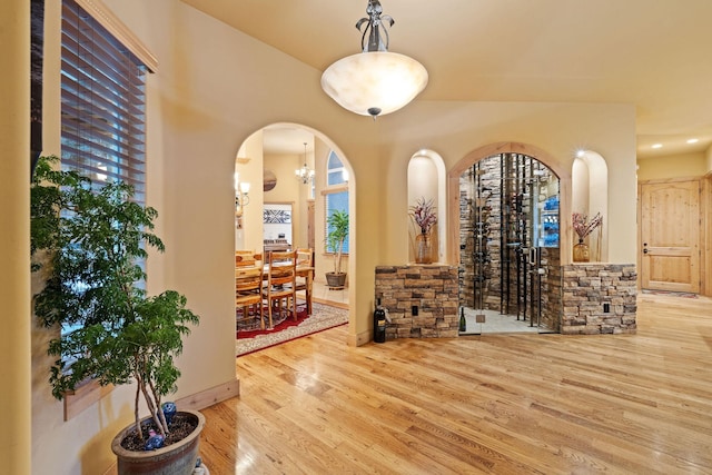 wine room with an inviting chandelier and light wood-type flooring