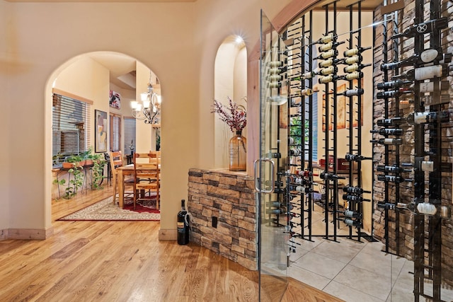 wine room with wood-type flooring and a chandelier