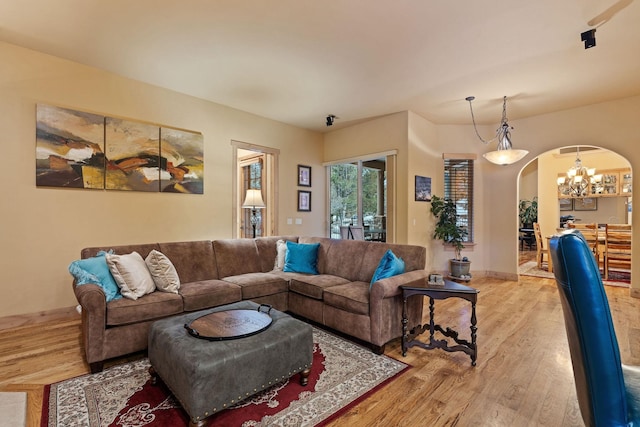 107 Whitetail Ct, Bigfork, MT 59911 - living room featuring arched walkways, wood finished floors, and a chandelier