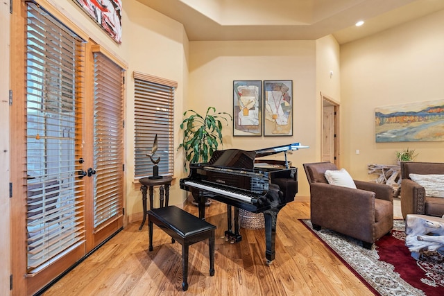 misc room with light hardwood / wood-style flooring and a high ceiling