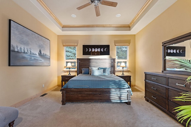 bedroom with ornamental molding, light carpet, and a tray ceiling