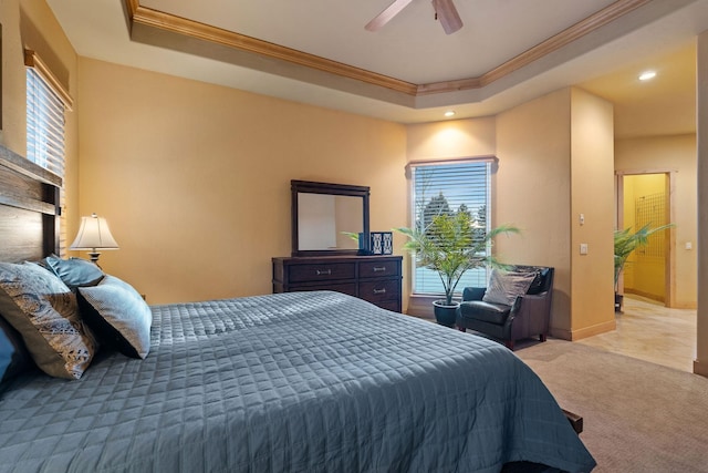 bedroom with crown molding, carpet flooring, a tray ceiling, and ceiling fan