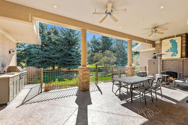 view of patio / terrace with ceiling fan, a grill, and exterior kitchen