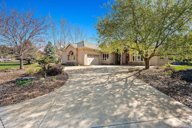 107 Whitetail Ct, Bigfork, MT 59911 - view of front of property featuring curved driveway, an attached garage, and stucco siding