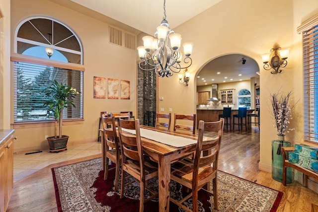 dining room featuring an inviting chandelier, hardwood / wood-style floors, and lofted ceiling