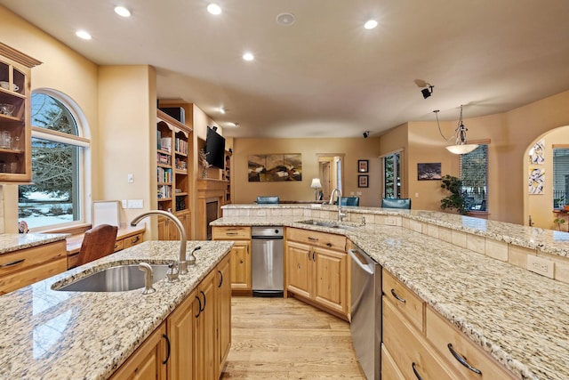 107 Whitetail Ct, Bigfork, MT 59911 - kitchen with stainless steel dishwasher, light stone counters, recessed lighting, light wood-type flooring, and hanging light fixtures