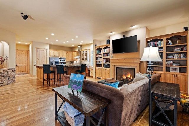 107 Whitetail Ct, Bigfork, MT 59911 - living room with a warm lit fireplace, light wood finished floors, and recessed lighting