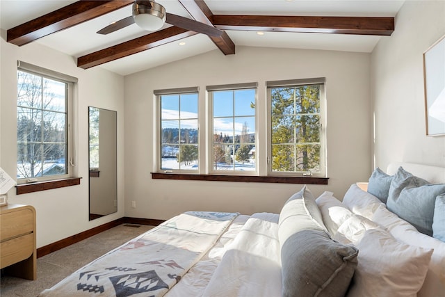 bedroom featuring light carpet, vaulted ceiling with beams, multiple windows, and ceiling fan