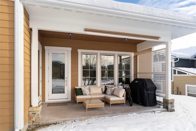 snow covered patio featuring outdoor lounge area and area for grilling