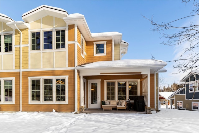 view of snow covered back of property