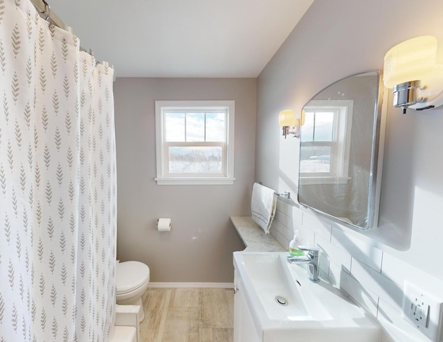 bathroom with tasteful backsplash, vanity, plenty of natural light, and toilet