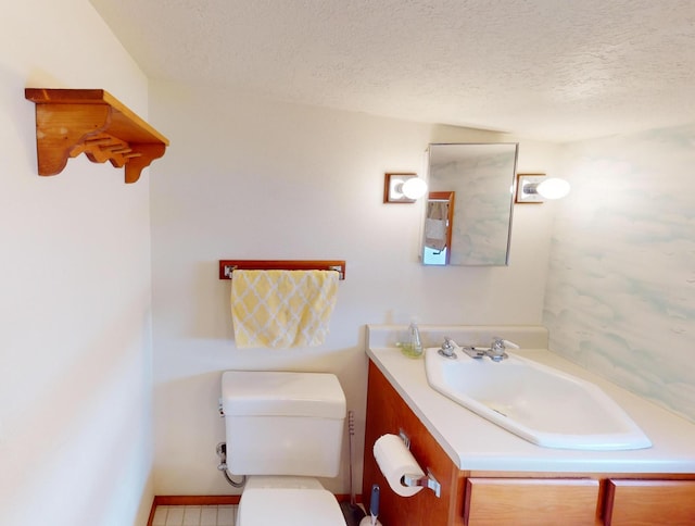 bathroom featuring vanity, toilet, and a textured ceiling