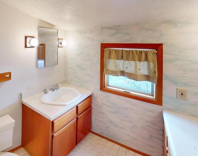 bathroom with vanity, a textured ceiling, and toilet