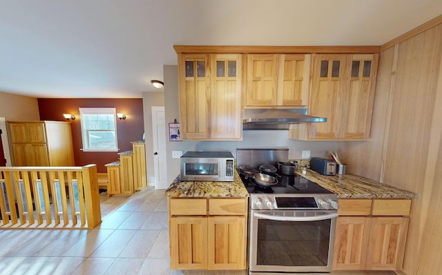 kitchen with stainless steel appliances, light brown cabinetry, light stone countertops, and light tile patterned floors