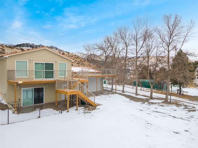 snow covered property with a wooden deck