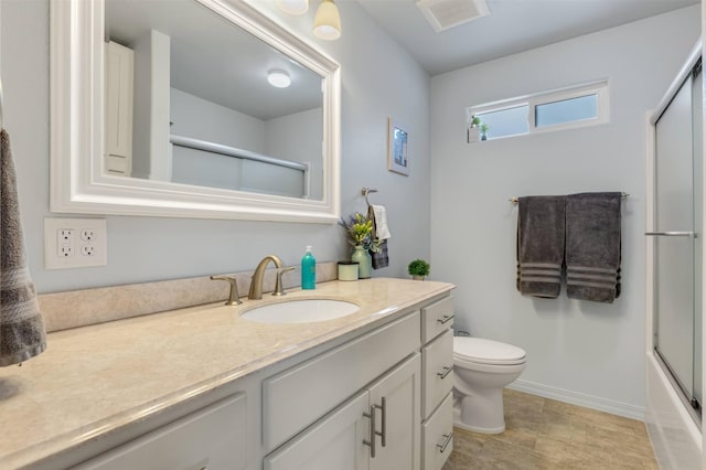 full bathroom with enclosed tub / shower combo, vanity, and toilet