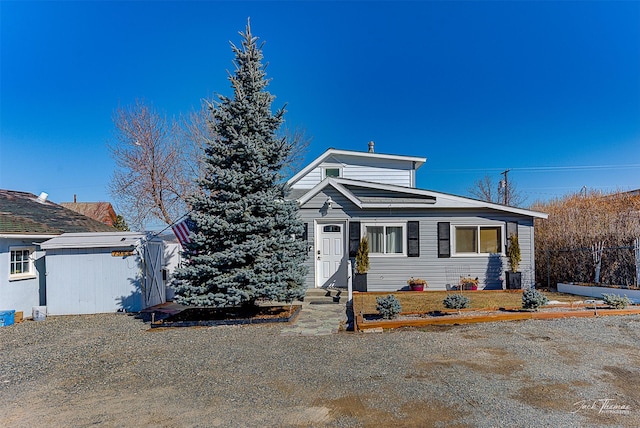 view of front of property with an outdoor structure, central AC unit, and a shed