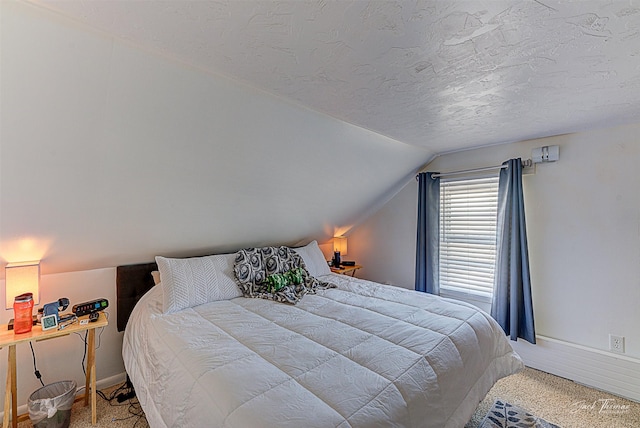 bedroom with a textured ceiling, lofted ceiling, and baseboards