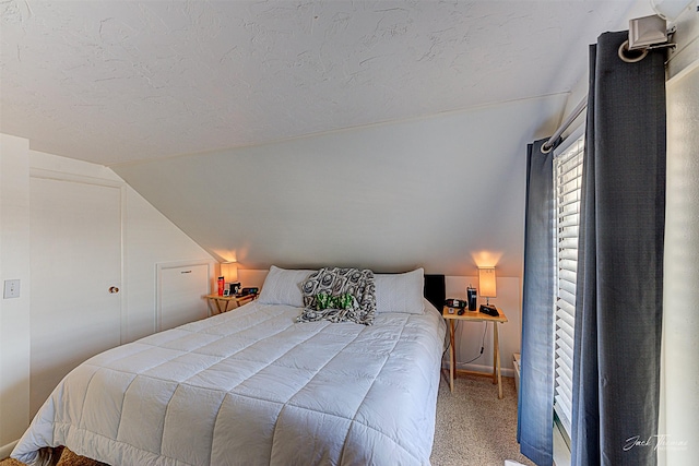 bedroom featuring lofted ceiling, carpet, and a textured ceiling